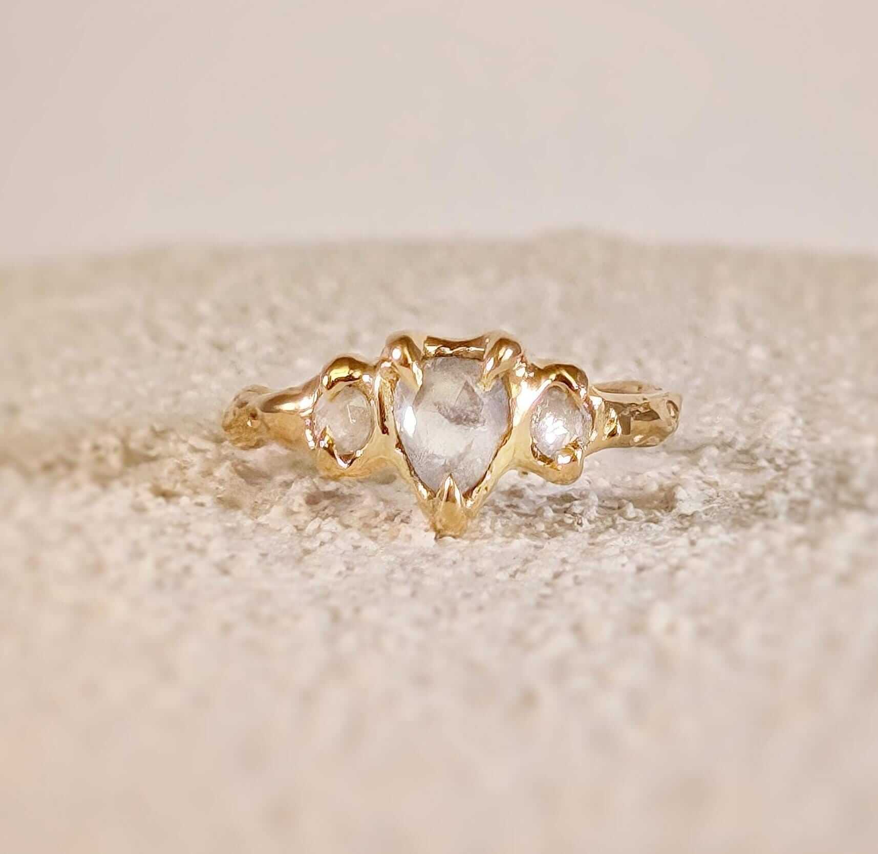 Rustic 14k gold engagement ring featuring heart-shaped Salt & Pepper diamond and two smaller diamonds.