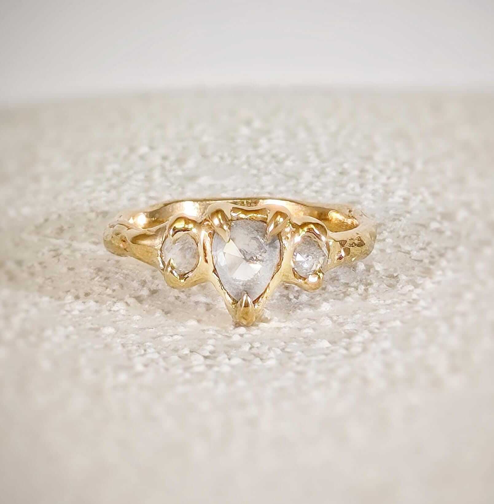 Rustic solid gold engagement ring featuring three Salt & Pepper diamonds set on a textured band.