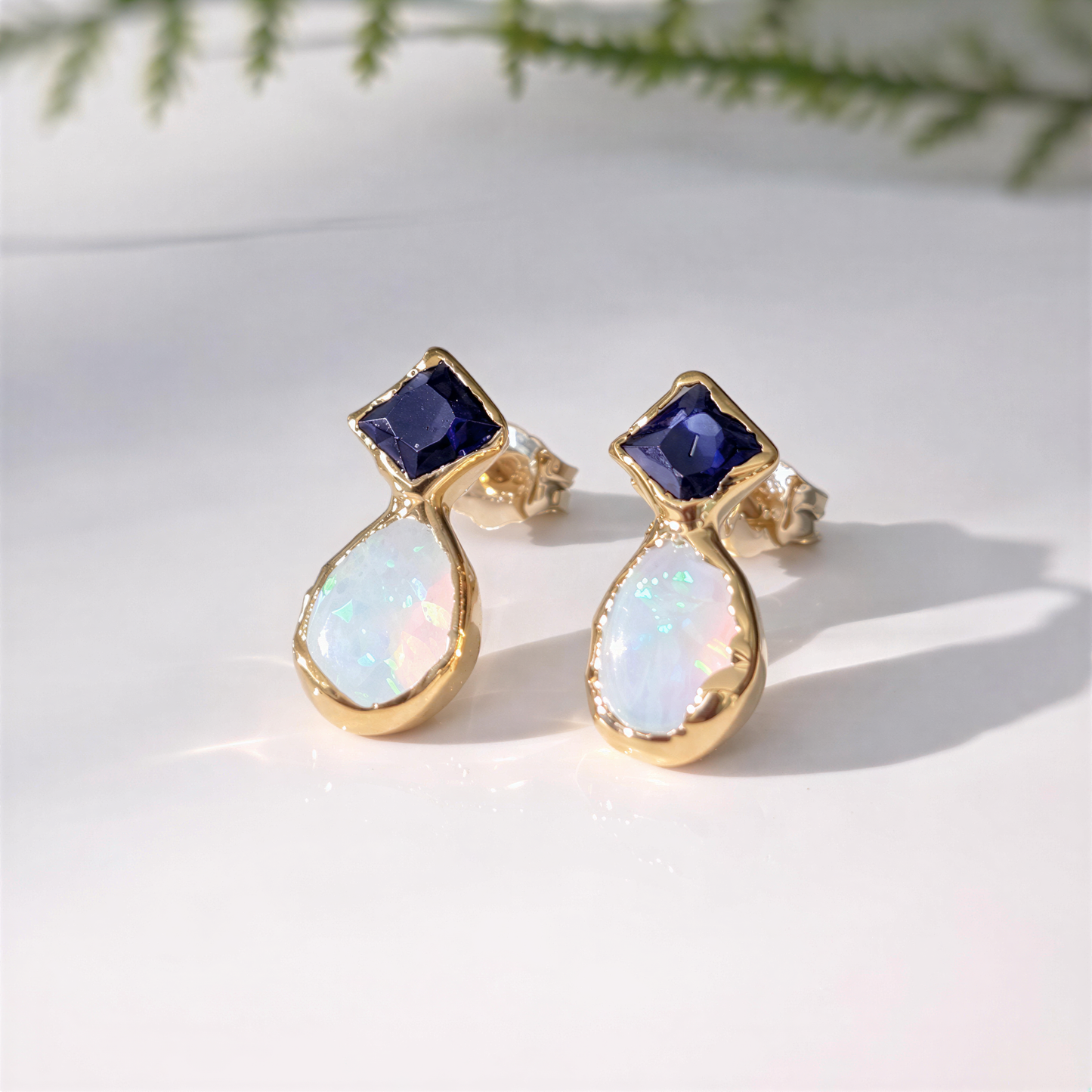 Blue Sapphire and Opal stud earrings in Gold, handcrafted design with elegant blue Sapphire and Opal stones.