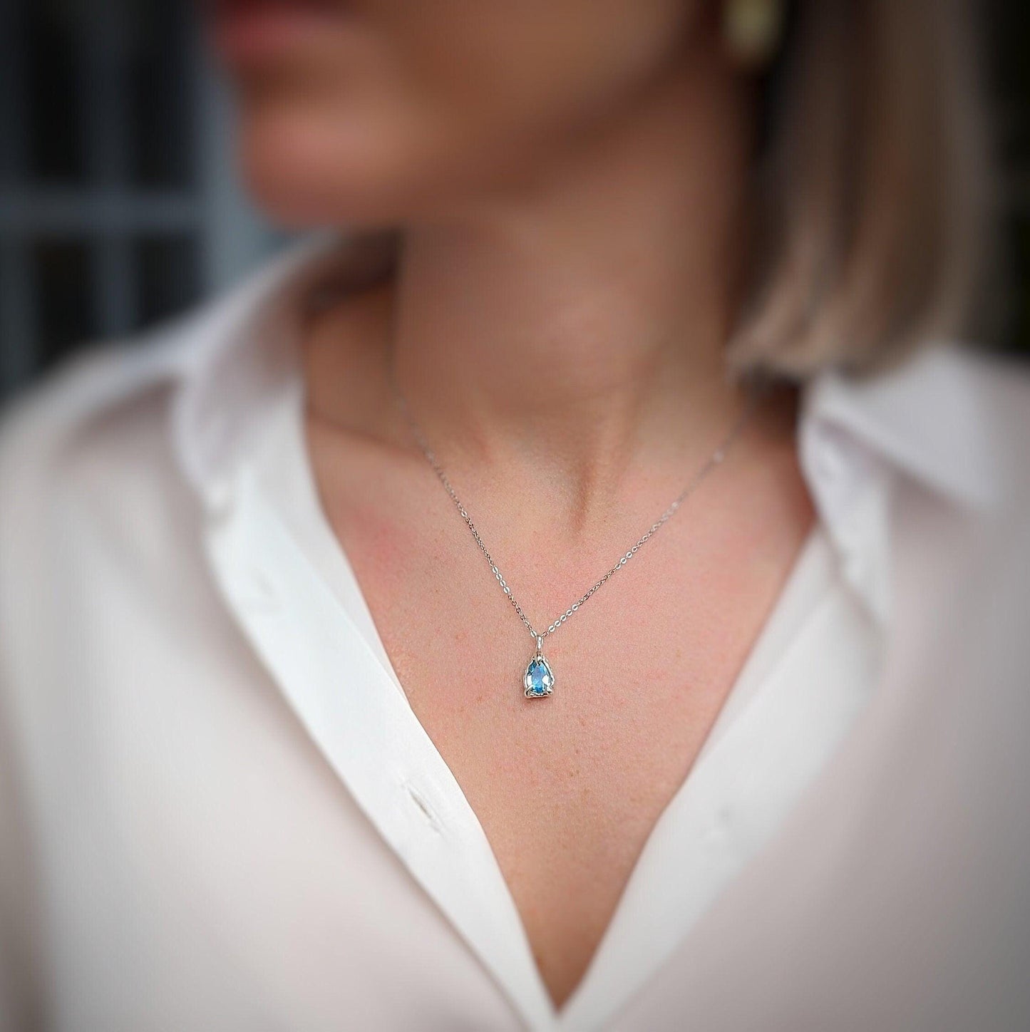 Silver aquamarine necklace worn on woman's neck