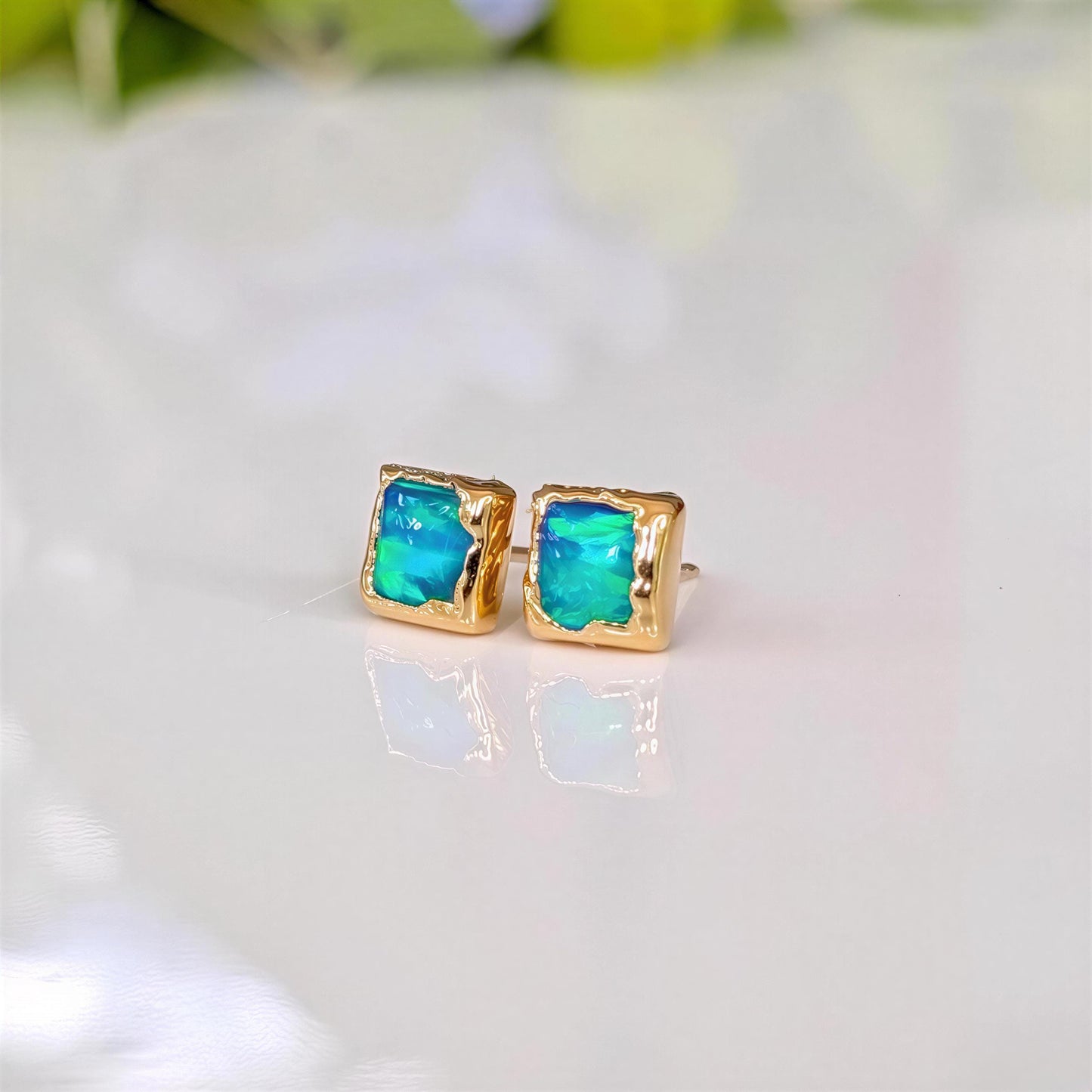 A pair of square shape flashy blue & green Opal stud earrings in Gold organic setting