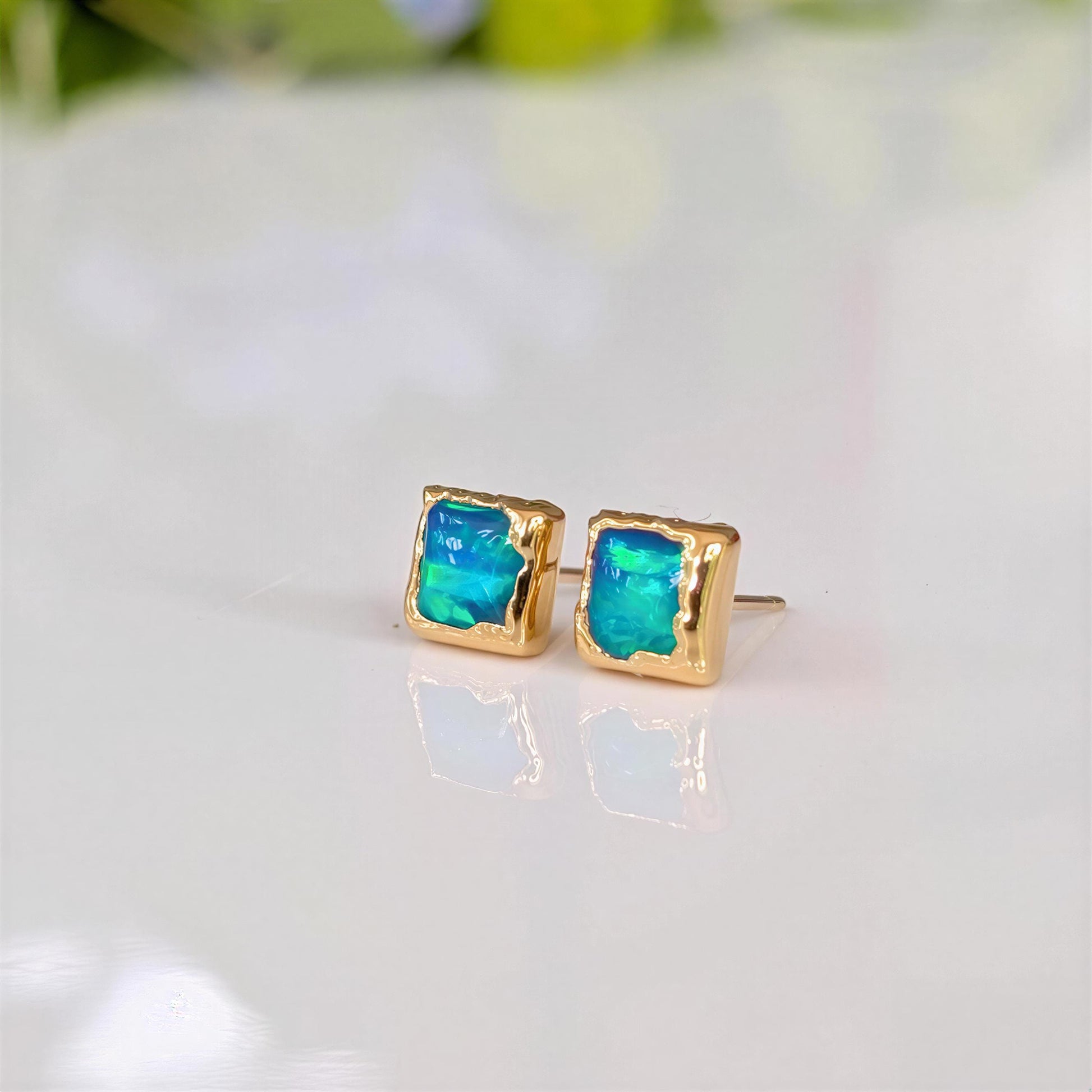 A pair of square shape flashy blue & green Opal stud earrings in Gold organic setting