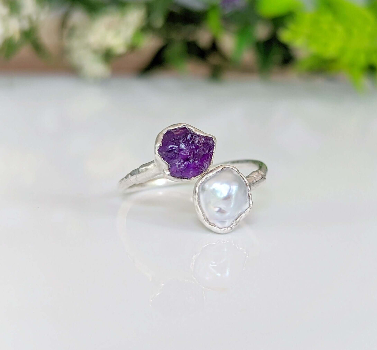 Toi et Moi raw gemstone ring featuring purple amethyst and white pearl on a silver band.