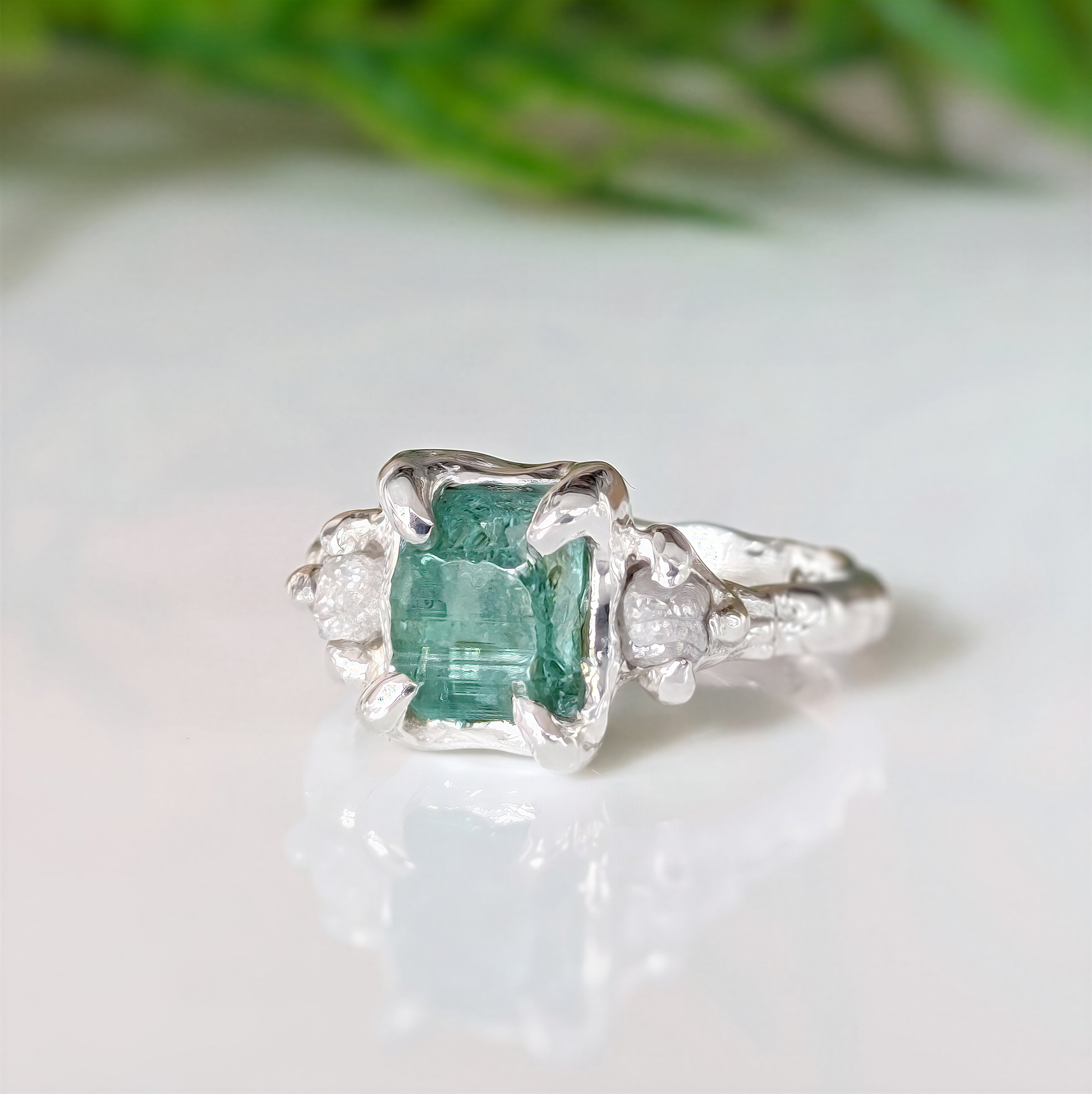 Raw emerald and diamond engagement ring in solid 14k gold with nature-inspired design.