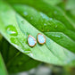 A pair of pear-shape white australian opal stud earrings in gold textured setting. The opals have lovely flashes of color.