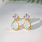 Gold stud earrings with Amethyst and Opal on a light background