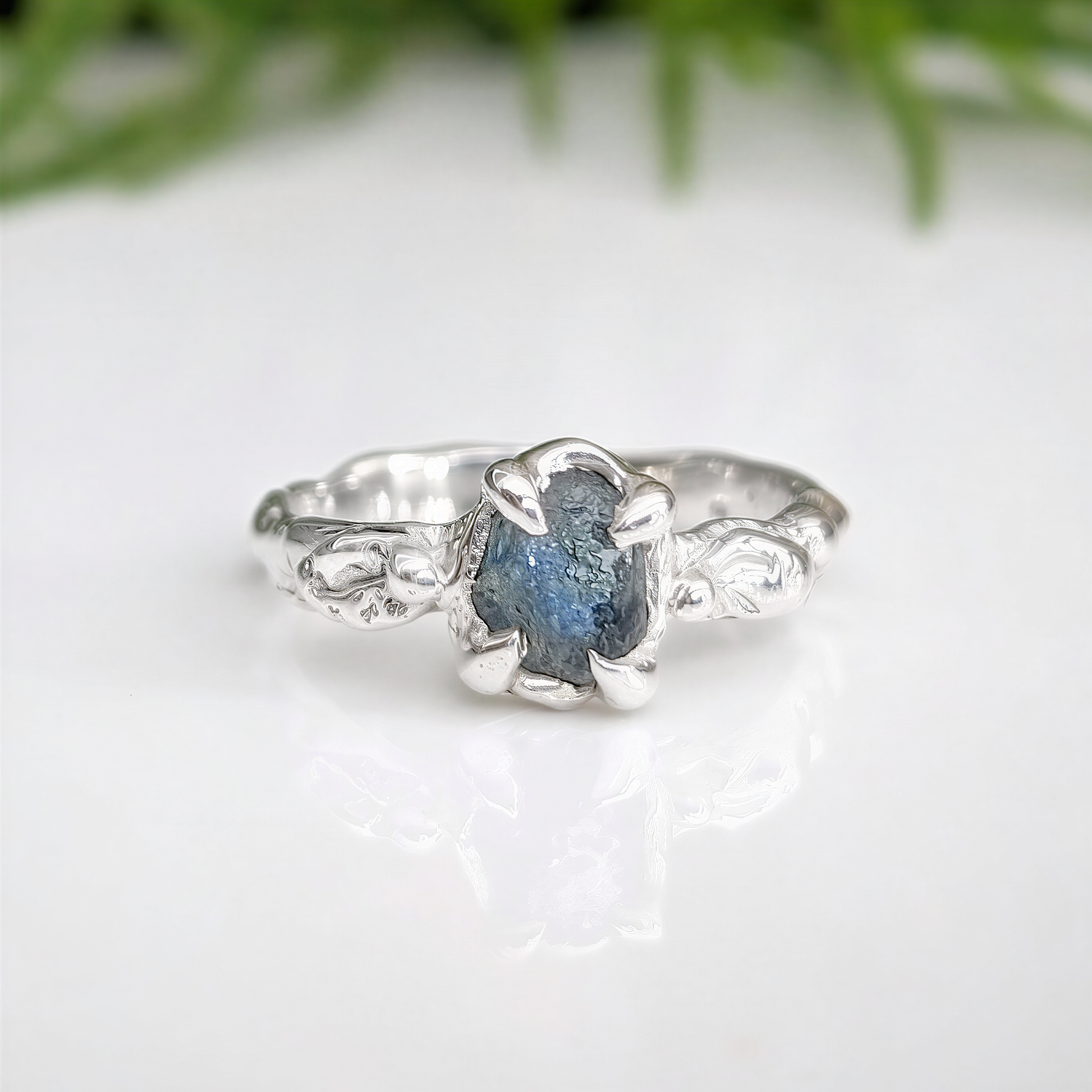 Raw Montana Sapphire silver ring with organic molten band, showcasing teal blue-green natural beauty.
