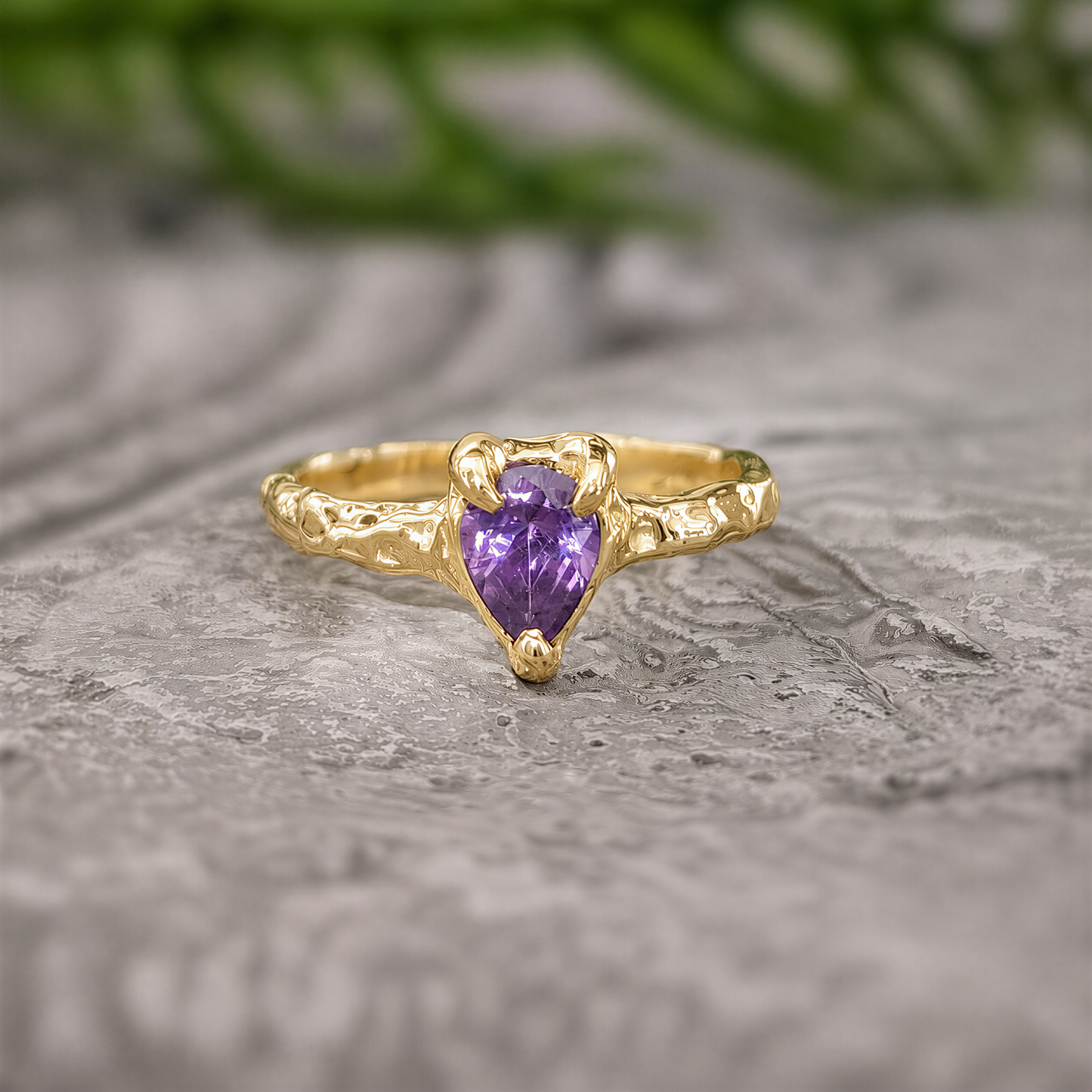 Solid Gold textured Amethyst ring on a stone surface