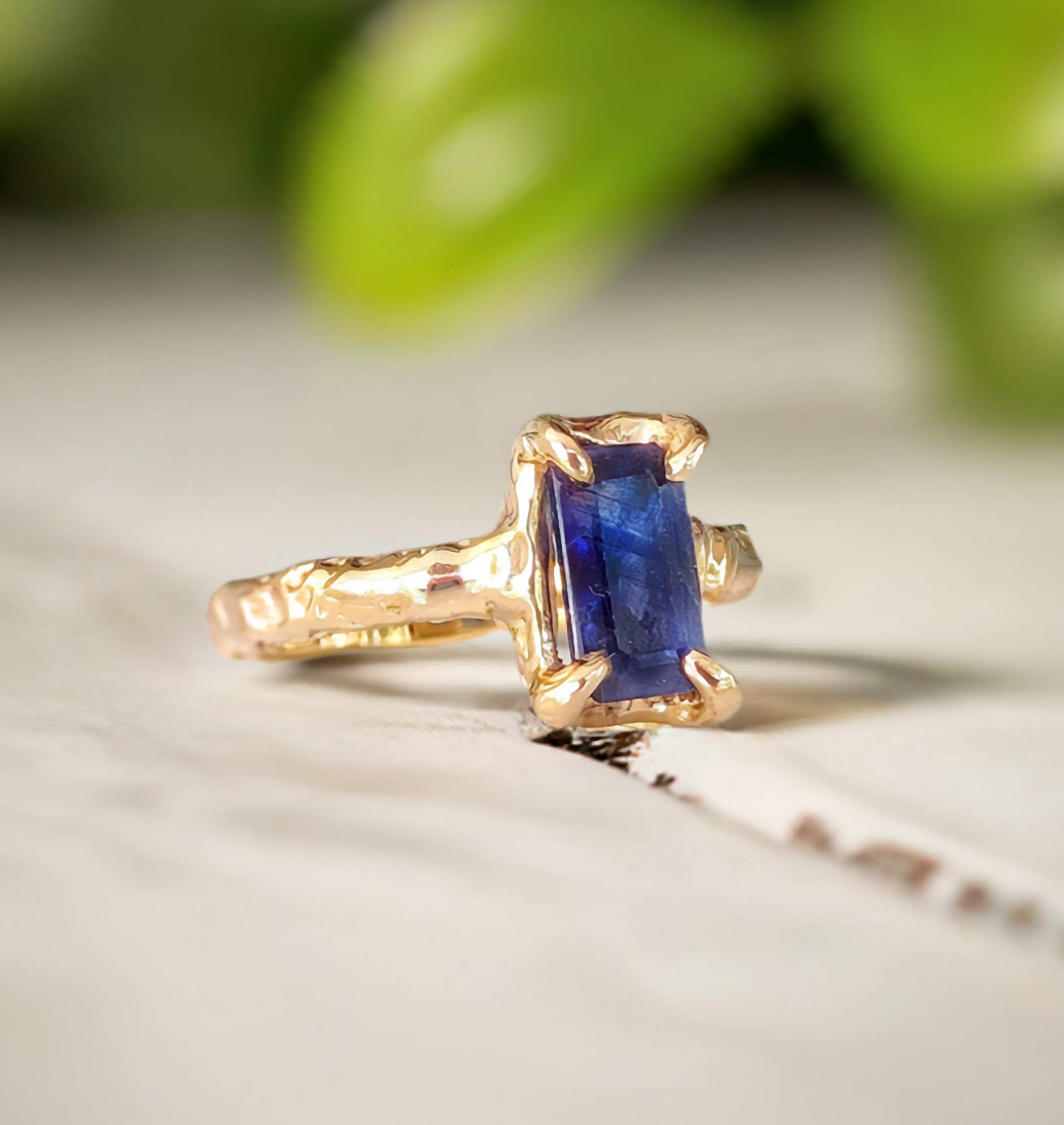 Blue sapphire cocktail ring in solid 14k gold with organic textured band, showcasing emerald shape lab-created sapphire.