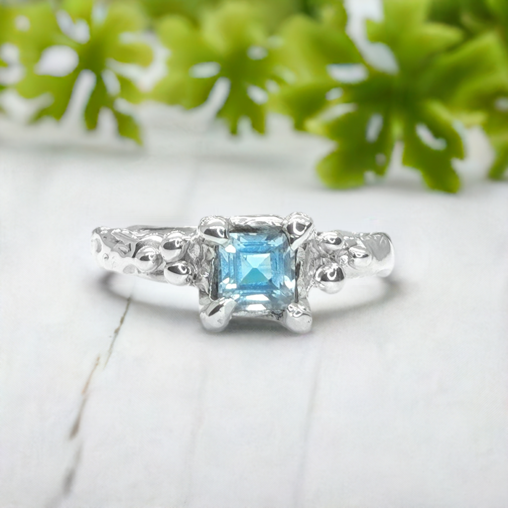 Handcrafted London Blue Topaz engagement ring in sterling silver with unique textured band.