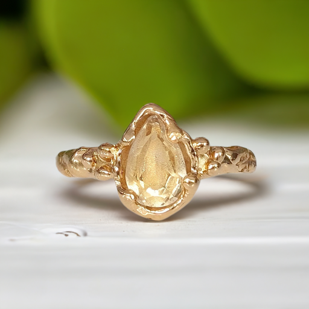 Citrine ring in solid 14k gold with a pear shape yellow crystal and textured band, perfect for an engagement.