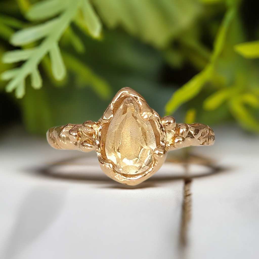 Handcrafted citrine ring in solid 14k gold with a pear-shaped gemstone and textured band, perfect for engagement.