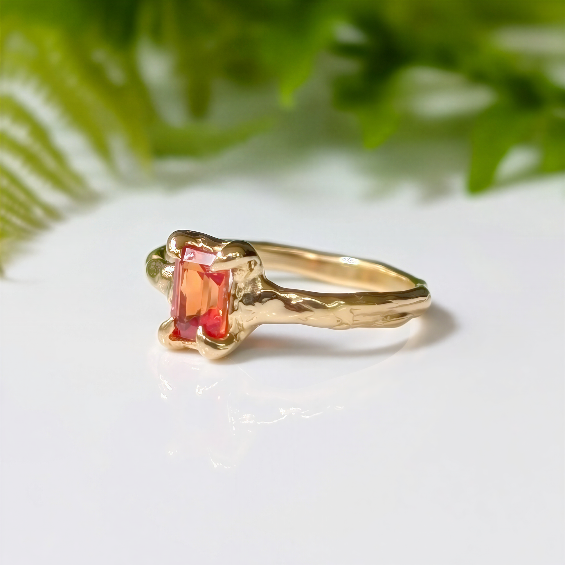 Handcrafted solid 14k gold ring featuring a radiant cut orange sapphire on a textured band.
