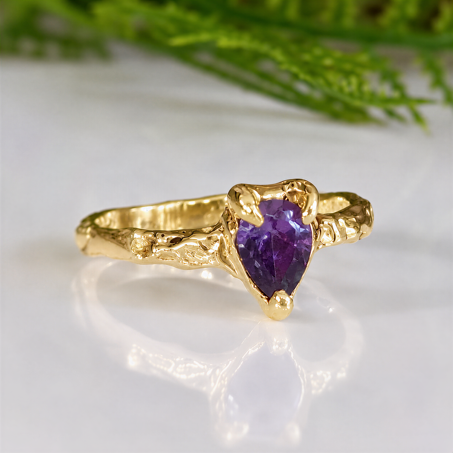 Solid Gold textured Amethyst ring on a white surface