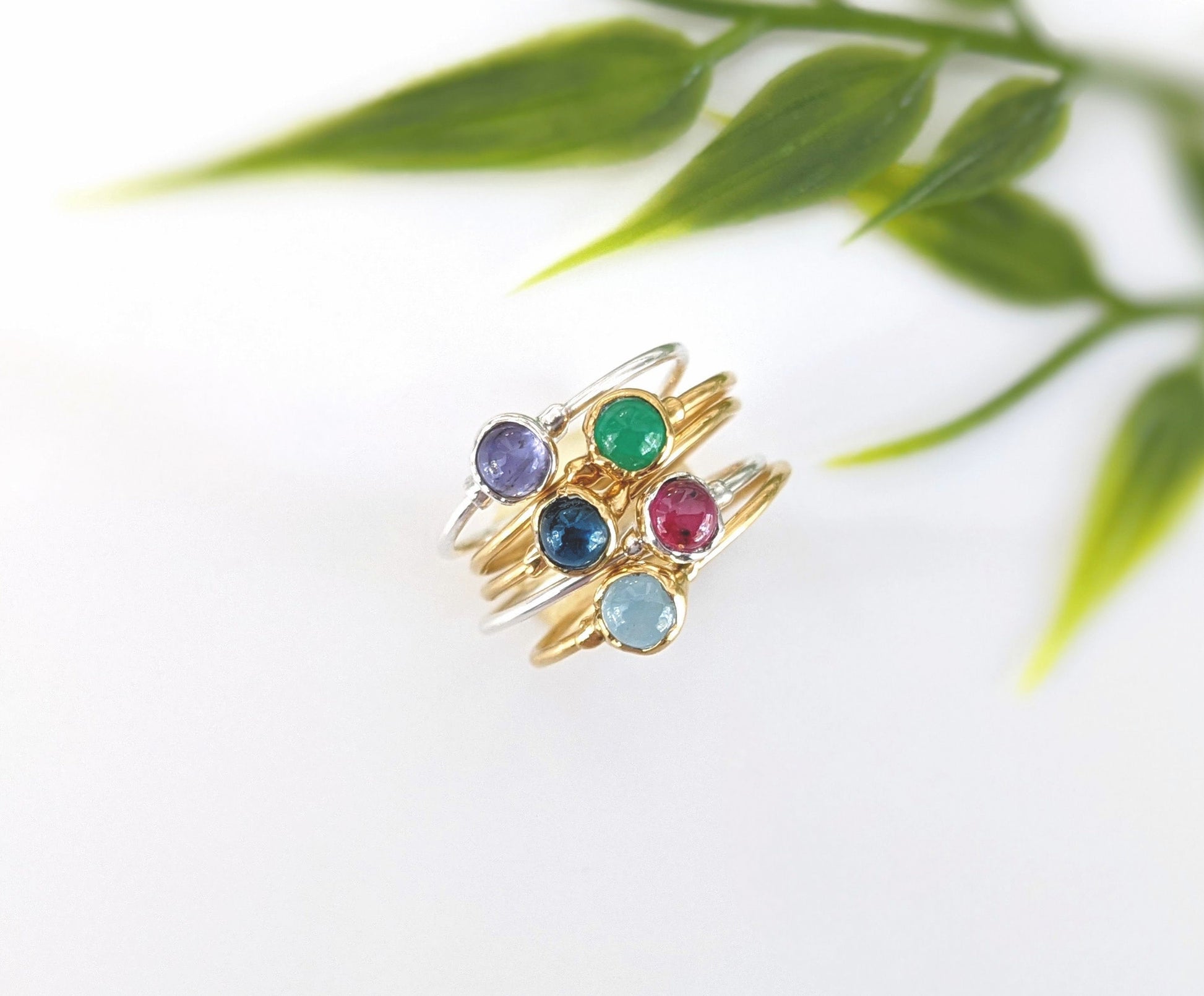 Stack of colorful gemstone rings featuring natural gems on gold and silver bands, perfect for stacking or everyday wear.