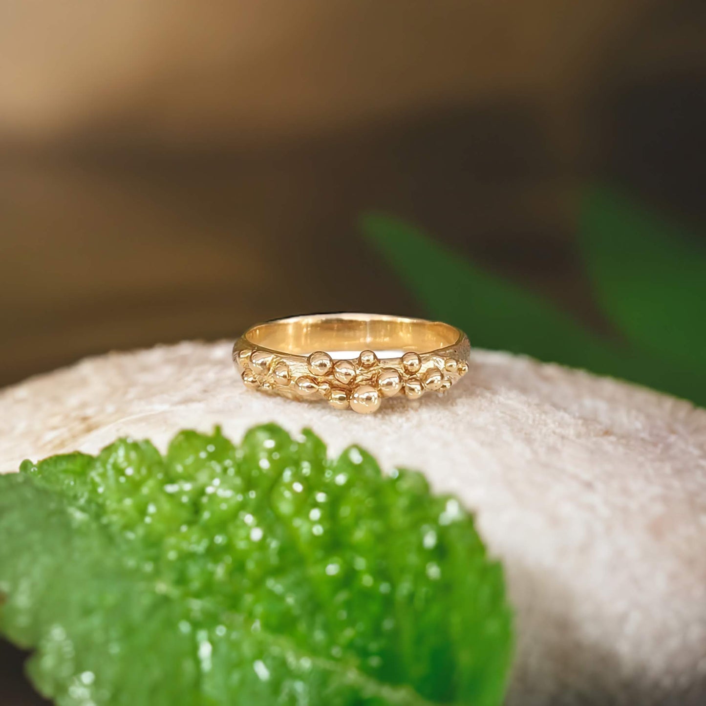 Solid 14k gold Dew Drop beaded ring on a soft surface, showcasing its organic design and handmade craftsmanship.