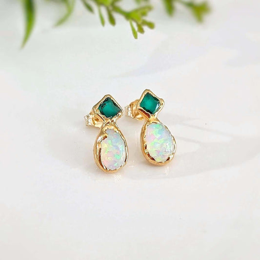 Gold stud earrings with green Emerald and opal stones on a light background
