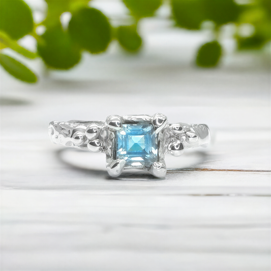 Blue Topaz engagement ring in solid sterling silver with an organic textured band for a unique and elegant look.