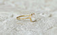 Handcrafted freshwater pearl ring on a textured stone surface, featuring a creamy-white Keshi pearl and a delicate gold band.