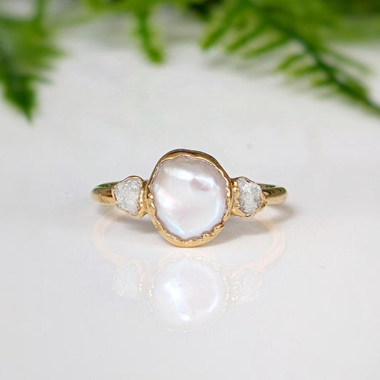 Freshwater pearl and raw diamond engagement ring with creamy-white pearl and rustic design, perfect for unique weddings.