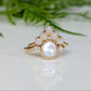 Freshwater pearl and raw diamond engagement ring with gold setting, showcasing a creamy pearl and rustic diamonds.