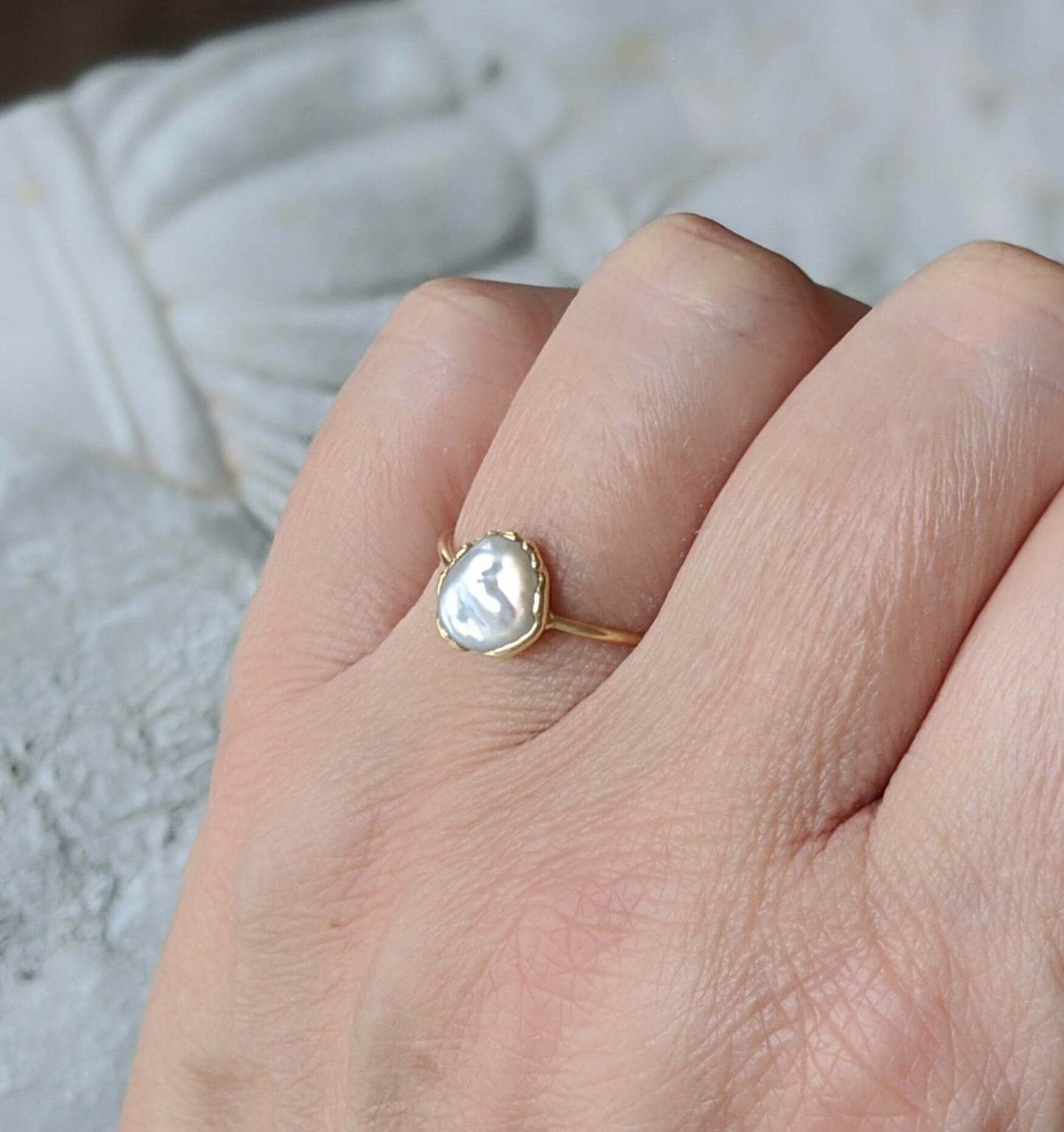 Elegant freshwater pearl ring set in gold, showcasing a unique Keshi pearl on a delicate band.