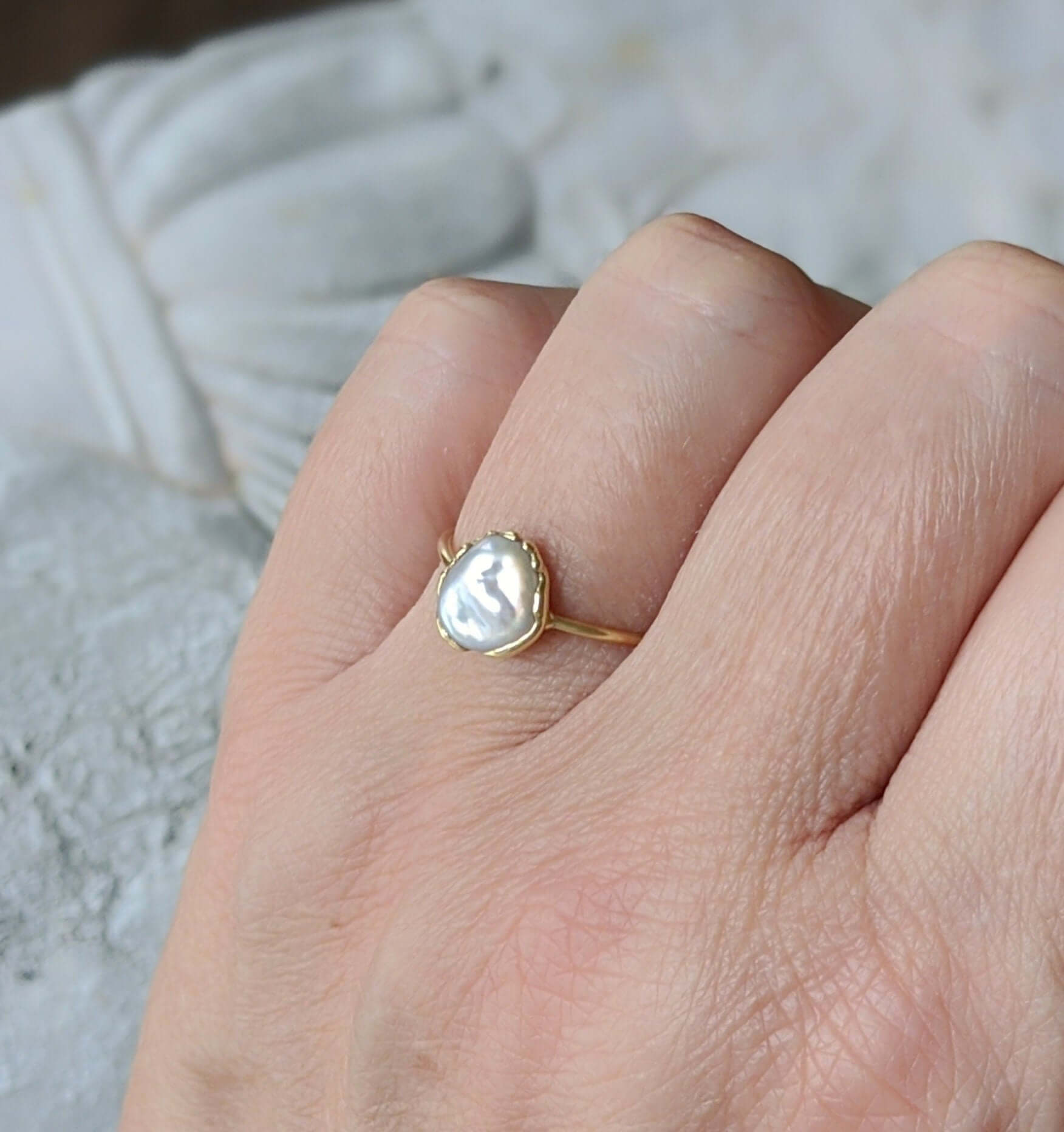 Elegant freshwater pearl ring set in gold, showcasing a unique Keshi pearl on a delicate band.