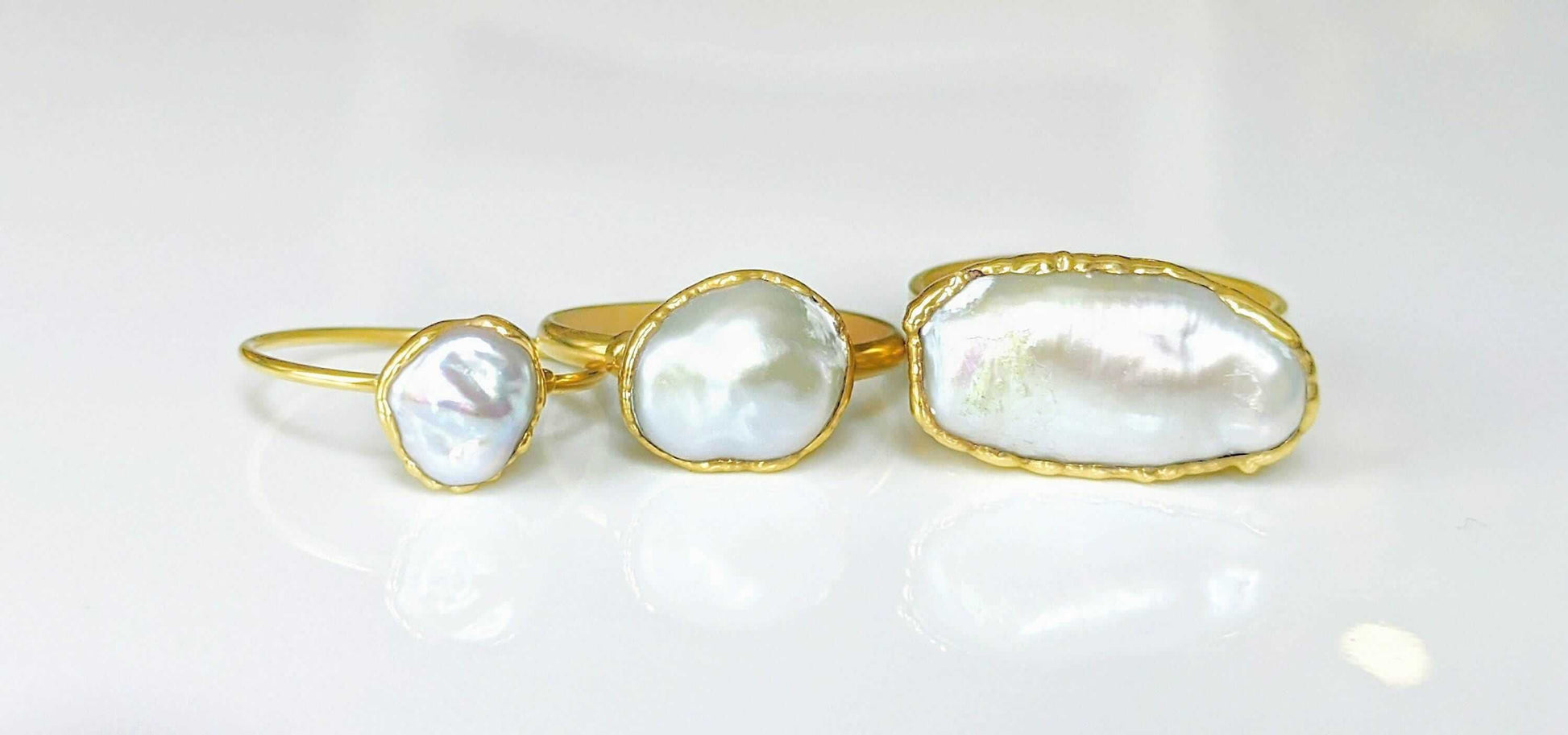 A selection of 3 Solid 14k Gold rings featuring different sizes of Freshwater Pearls