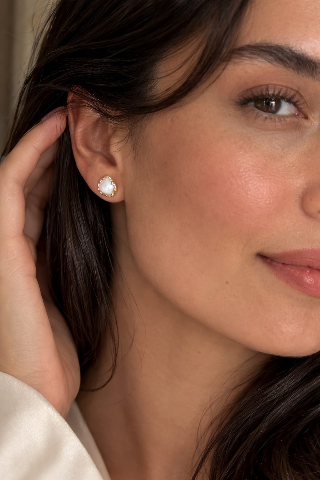 Close-up of a woman wearing a diamond earring with a blurred background