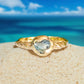 Australian sapphire ring in solid 14k gold with textured band, set against a beach backdrop.
