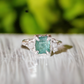Raw Emerald and diamond engagement ring in solid sterling silver with a mint green emerald and two small diamonds.