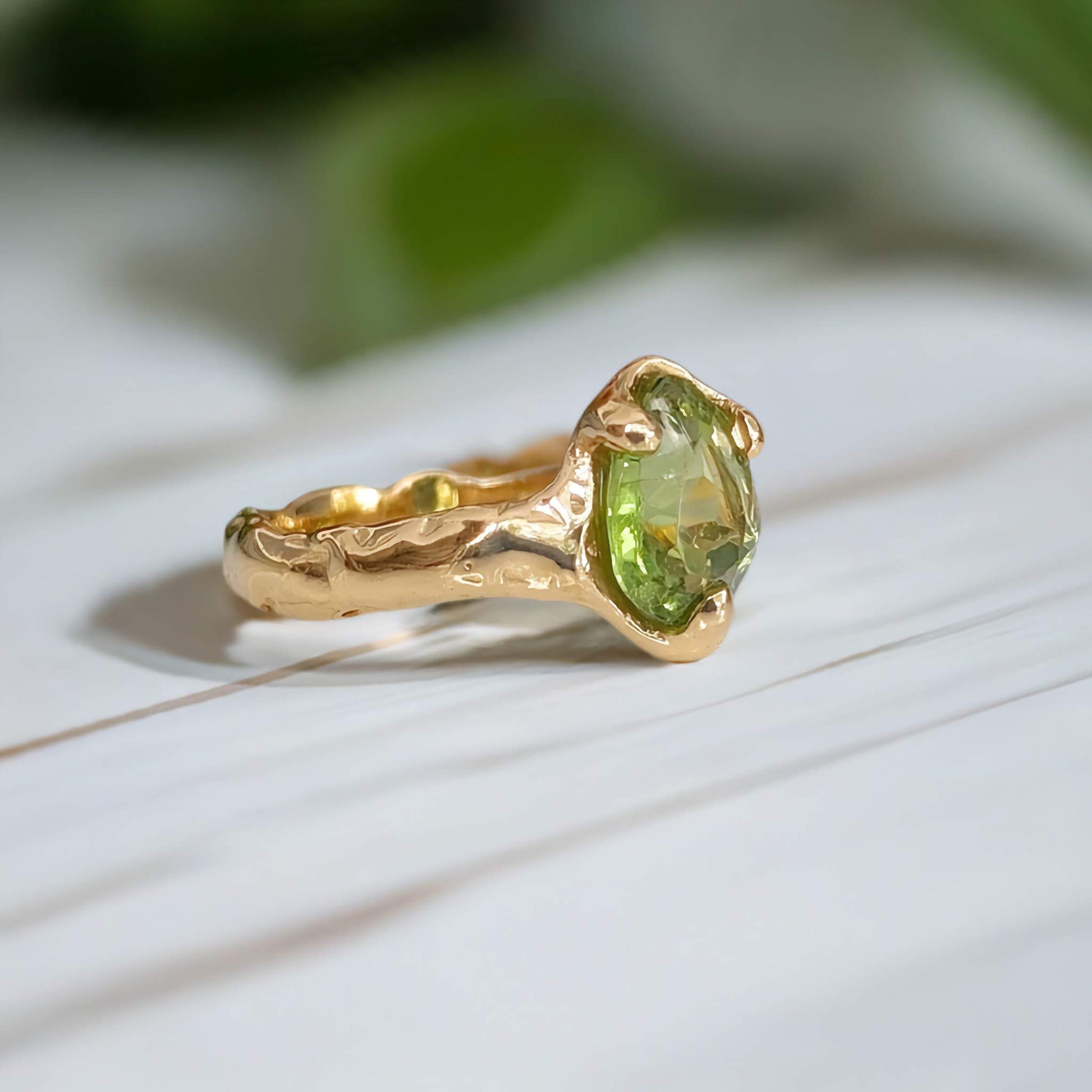 Handcrafted solid 14k gold Peridot ring with organic textured band, showcasing vibrant green crystal.