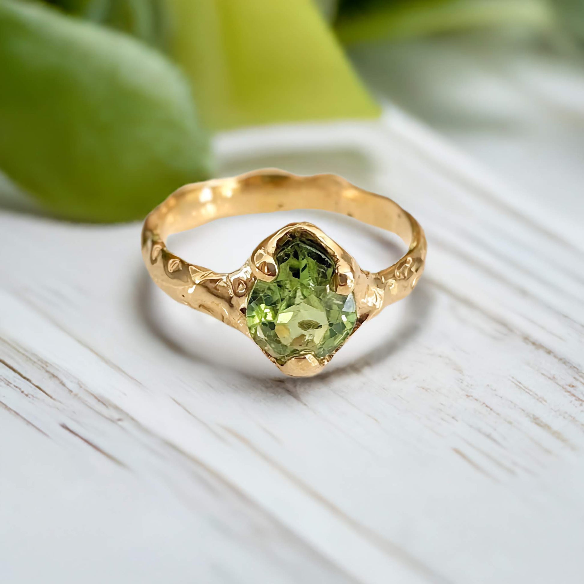 Handcrafted 14k gold Peridot ring with organic textured band, showcasing a vibrant green gemstone.