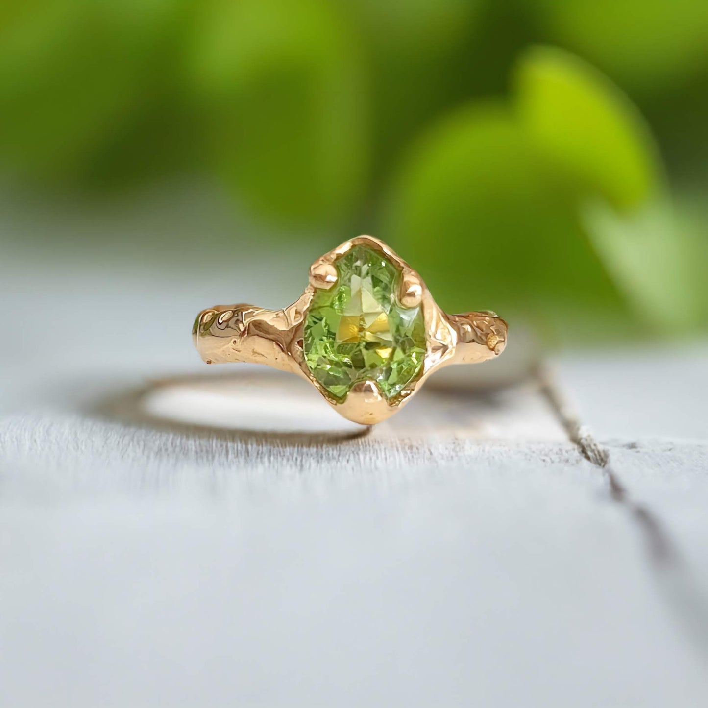 Handcrafted solid 14k gold Peridot ring with unique organic textured band, showcasing the vibrant green gemstone.