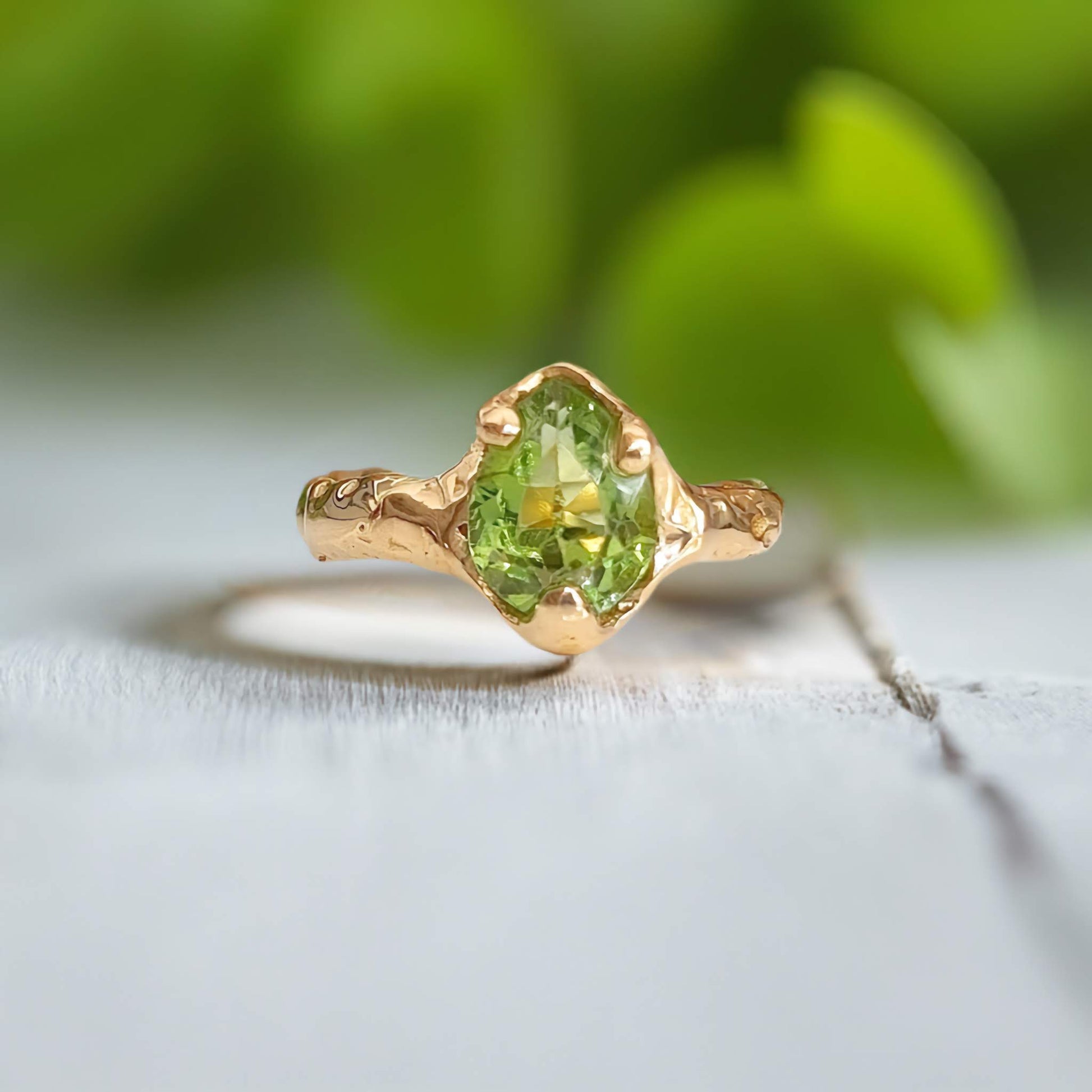 Handcrafted solid 14k gold Peridot ring with unique organic textured band, showcasing the vibrant green gemstone.