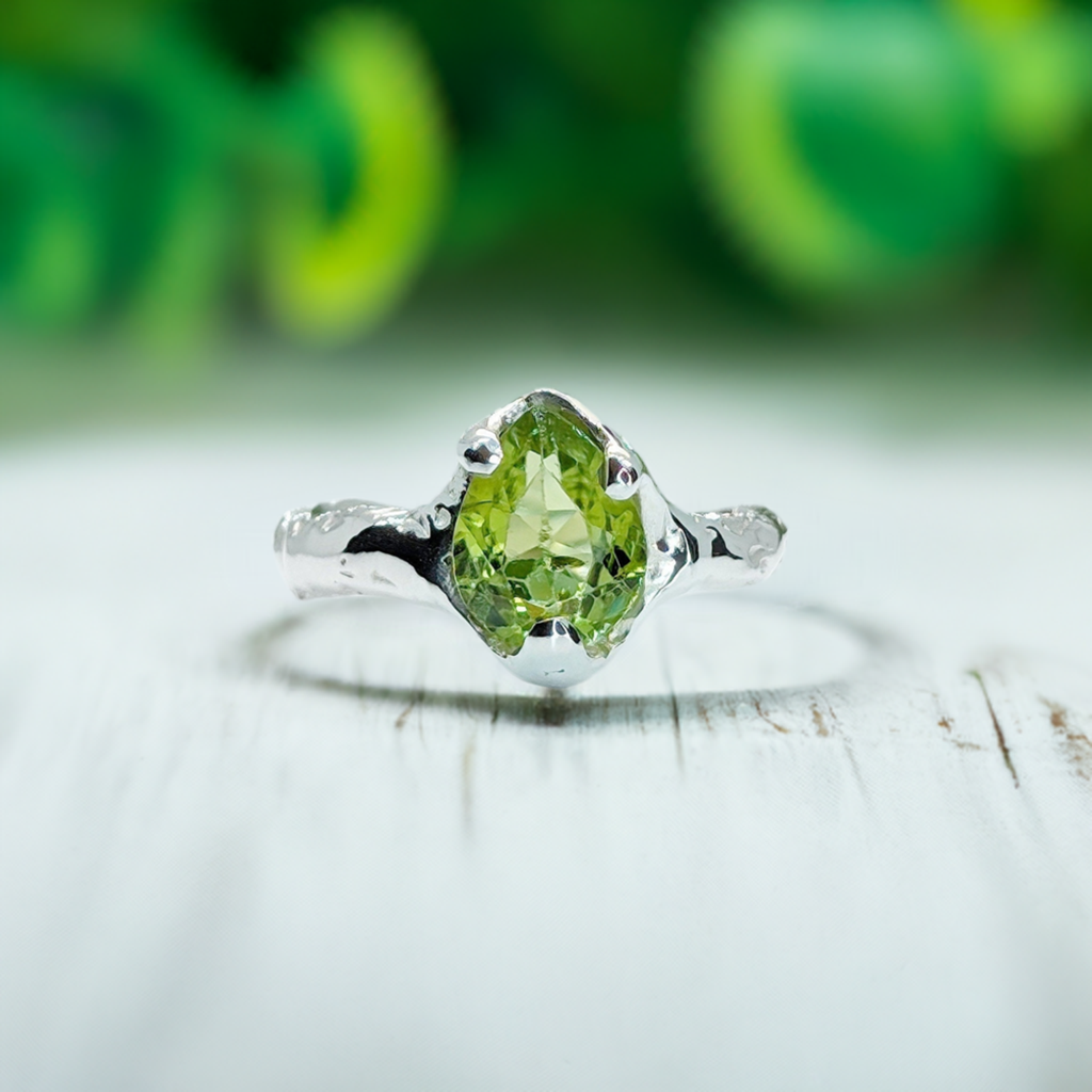 Handcrafted sterling silver ring featuring a rose cut peridot gemstone, elegant and rustic design.