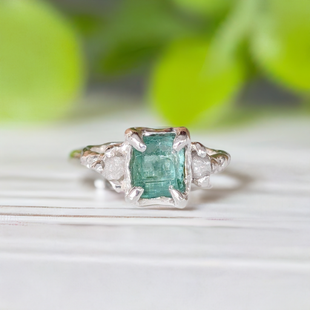Raw Emerald and diamond engagement ring in solid sterling silver, showcasing mint green emerald and two small diamonds.