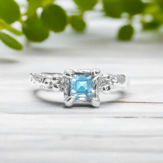 Handcrafted London Blue Topaz engagement ring in solid sterling silver with organic textured band.