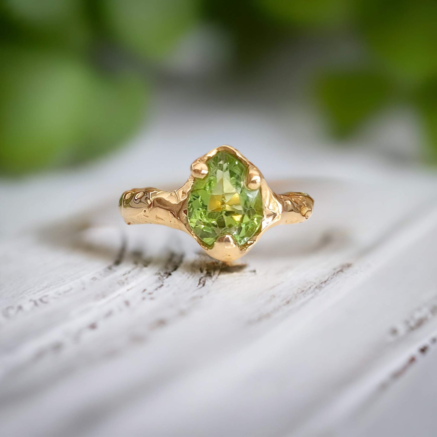 Handcrafted Solid 14k Gold Peridot ring with organic textured band, highlighting the green crystal stone.