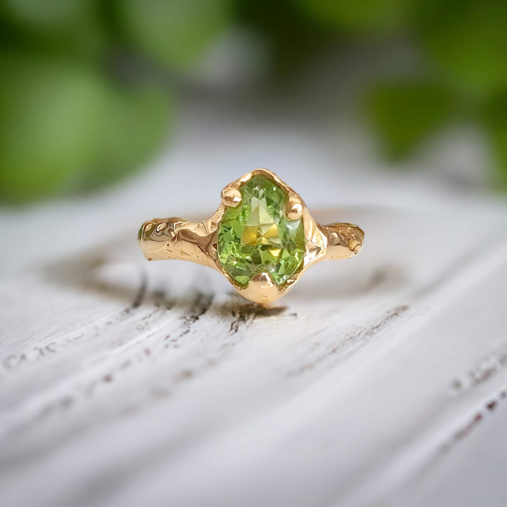 Handcrafted Solid 14k Gold Peridot ring with organic textured band, highlighting the green crystal stone.