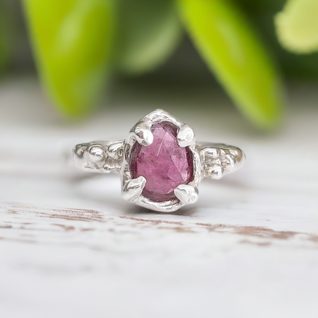 Hand-carved pink sapphire ring in solid sterling silver, showcasing a unique textured design and pear-shaped stone.