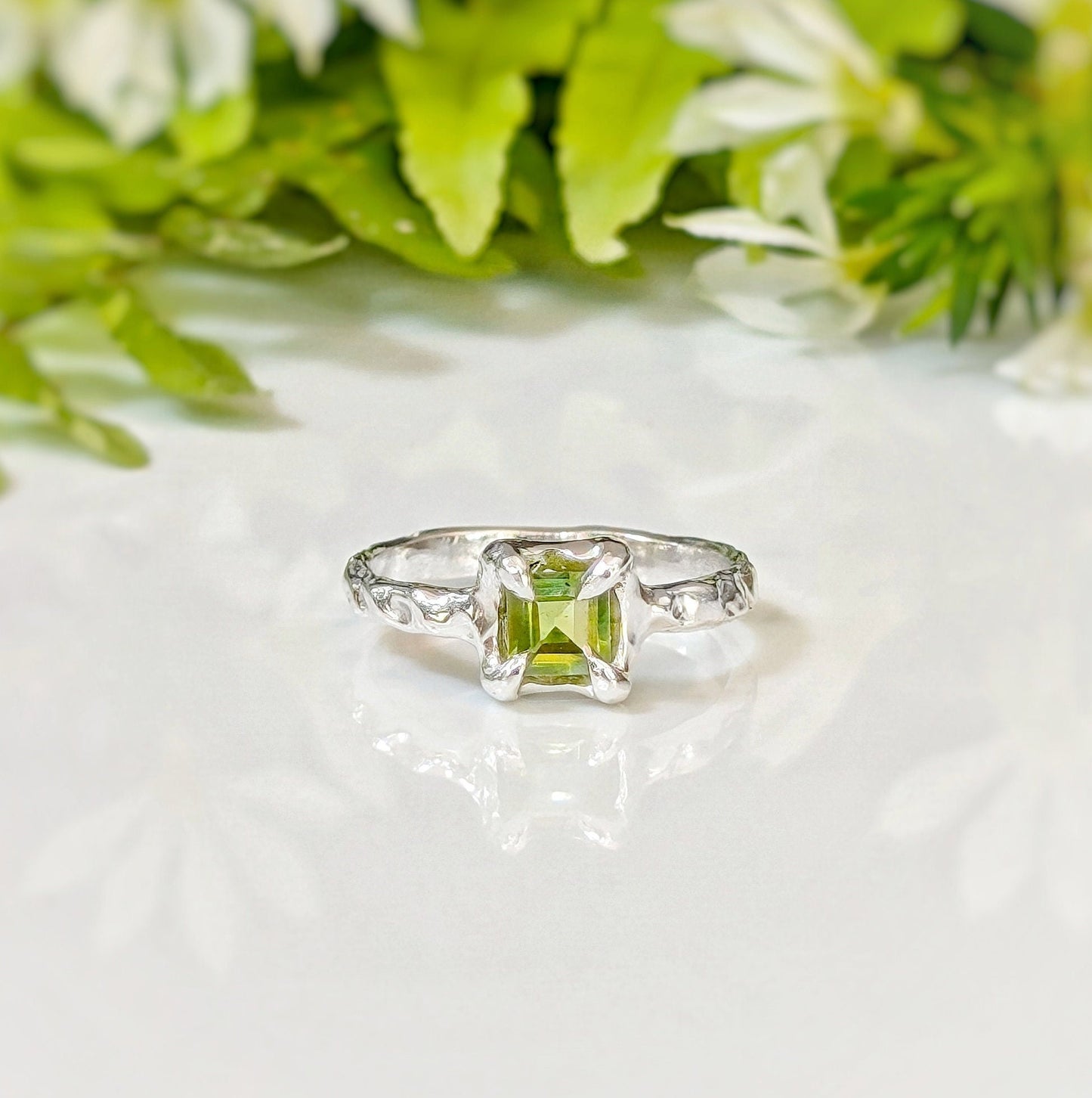 Handcrafted solid silver ring featuring a princess-cut Peridot, surrounded by an organic textured band, perfect for engagements.
