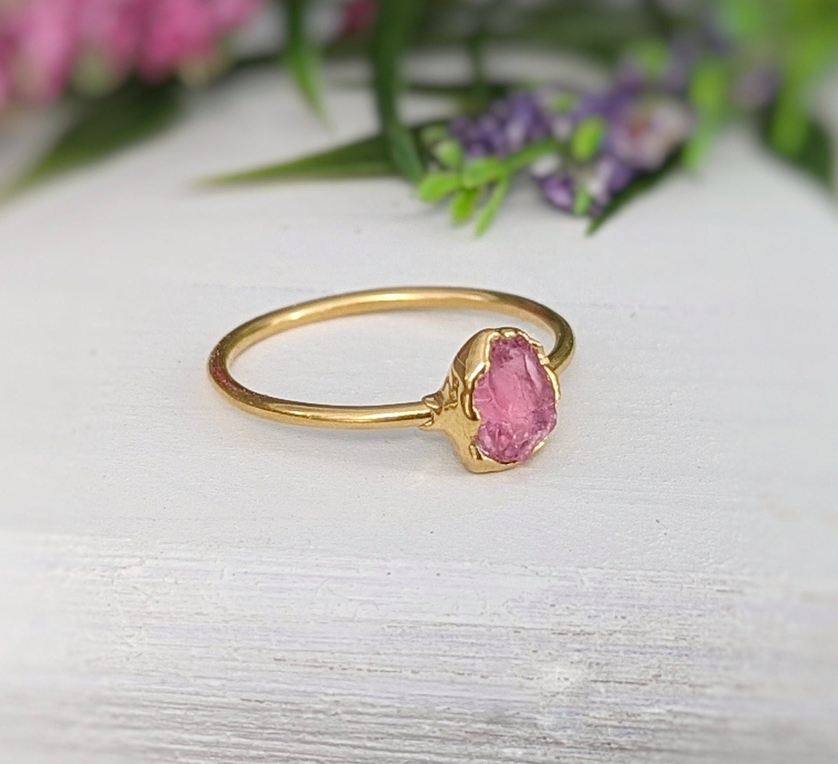 Raw pink spinel ring with gold setting, showcasing natural blush hues and unpolished edges, perfect for gifts.