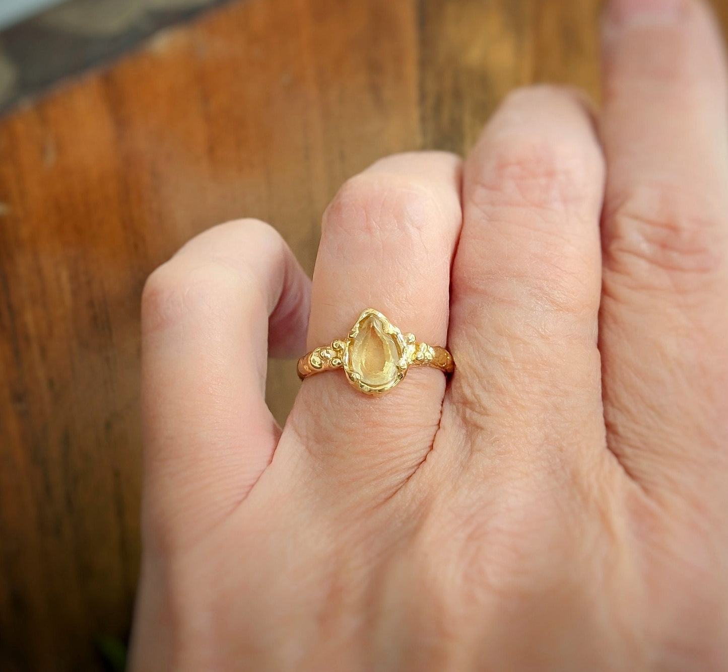 Handcrafted natural Citrine silver ring featuring a pear-shaped yellow crystal, showcasing its unique organic design.