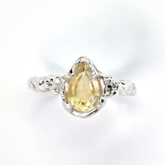 Handcrafted natural Citrine silver ring with pear-shaped yellow crystal and textured band, perfect for engagement.