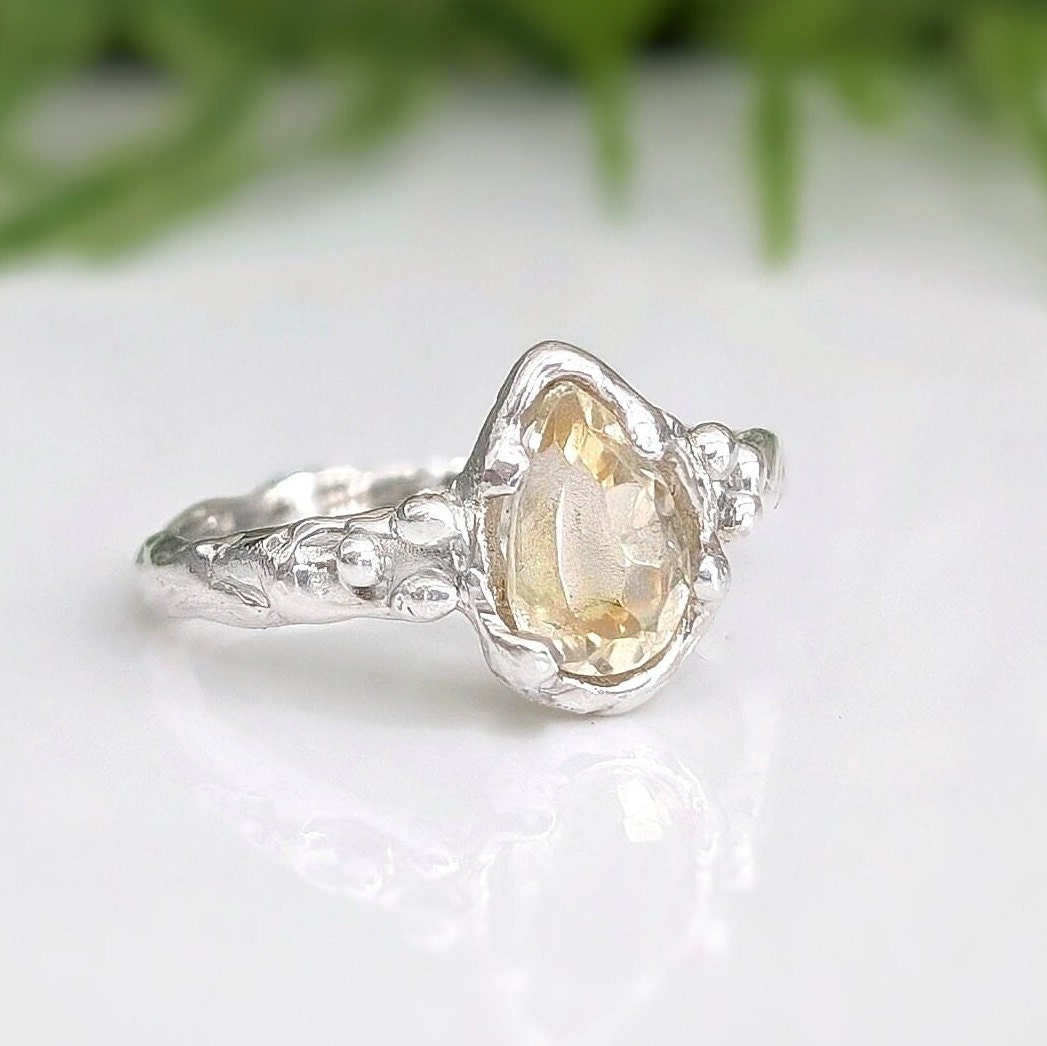 Handcrafted pear shape citrine silver ring with a textured band, showcasing natural charm and elegance.