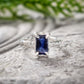 Blue Sapphire engagement ring in solid 14k gold with an emerald-cut lab-created stone and textured band.