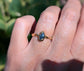 Hand wearing a unique Australian Sapphire ring in solid 14k gold from the 'Pea in a Pod' Collection.