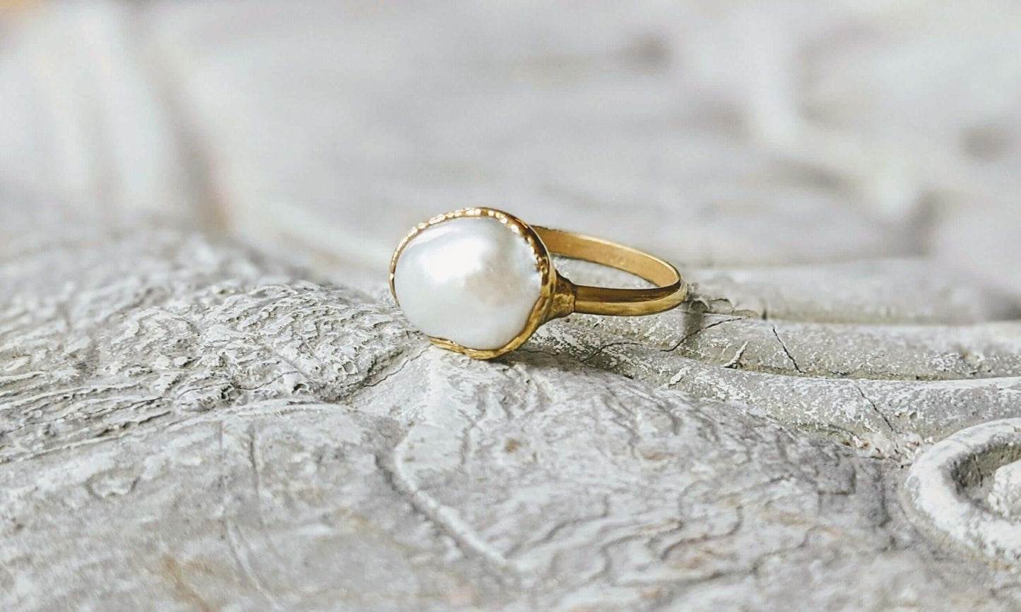 A Solid 14k Gold ring featuring a large Freshwater Pearl