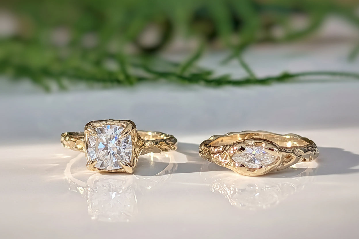 Two Gold Moissanite engagement rings, one with an 8mm Cushion gemstone, the  other with a Marquise cut Moissanite - both set in a Molten textured design